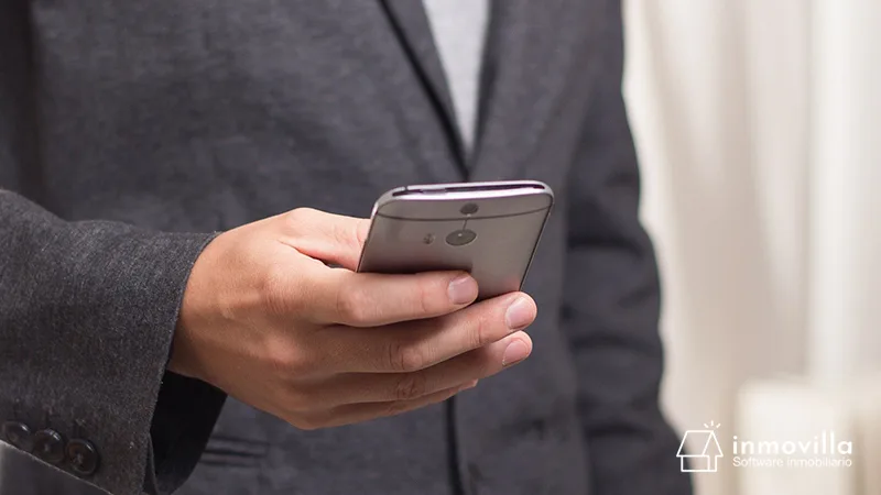 Asesor inmobiliario llamando a cliente desde su teléfono móvil.
