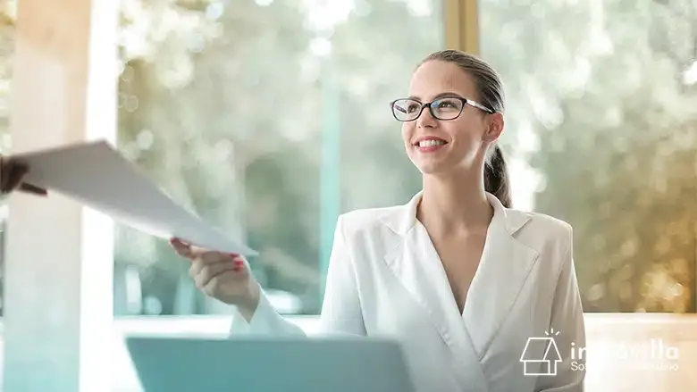 Persona recibiendo un informe de un perito judicial inmobiliario.